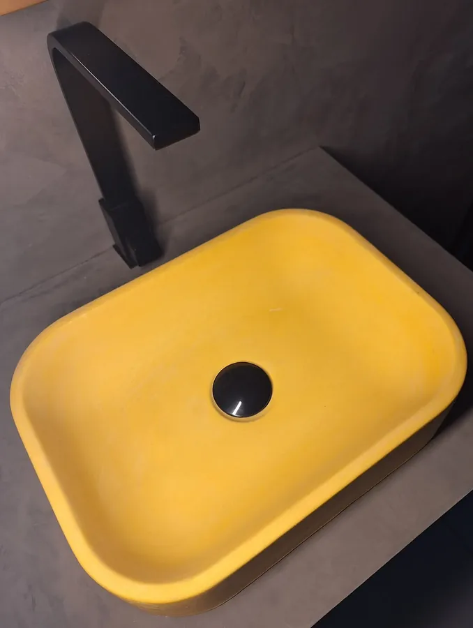 Yellow concrete sink installed with matte black faucet