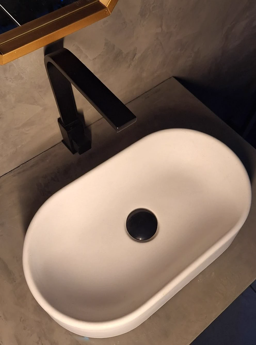 White concrete sink installed with matte black faucet