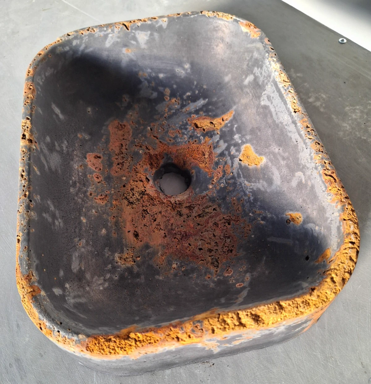 Concrete sink with dark rust-effect finish