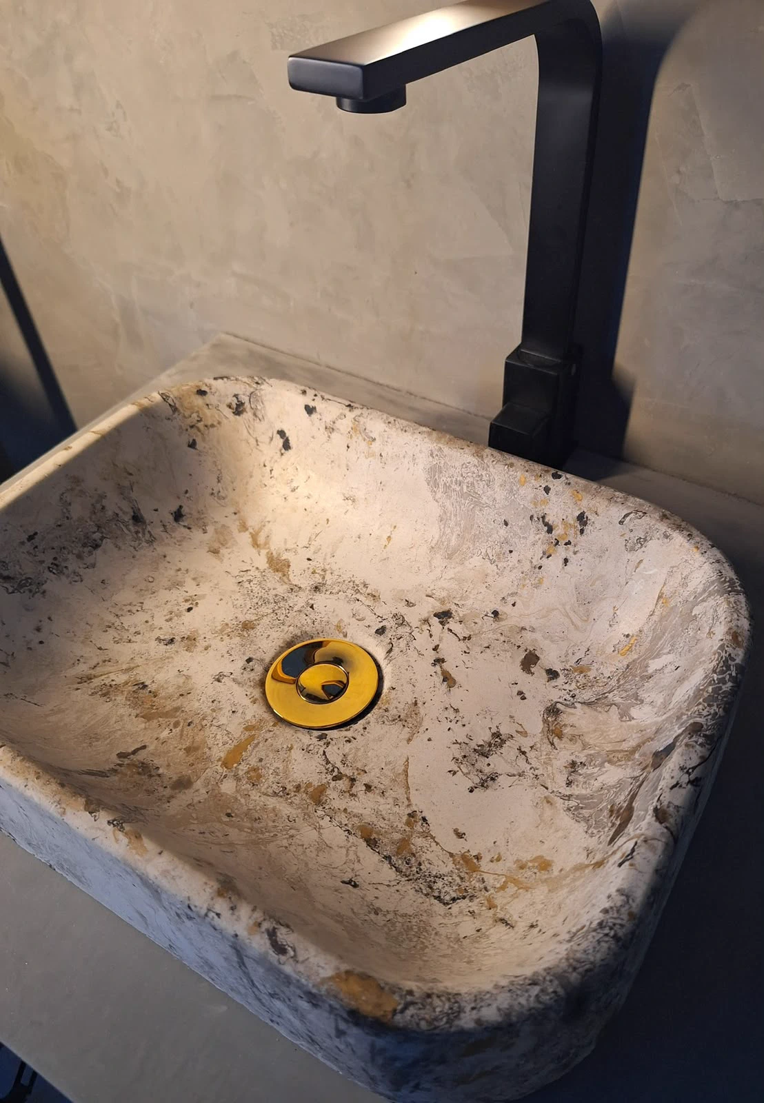 Marble-effect concrete sink installed with matte black faucet